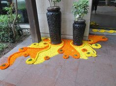 three black vases with plants in them on the ground