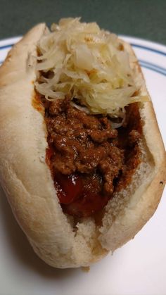 a close up of a hot dog on a plate with coleslaw and meat