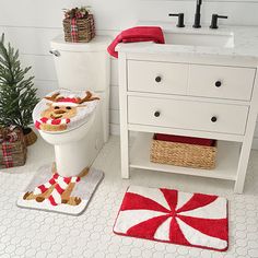 a white toilet sitting next to a christmas tree in a bathroom on top of a rug