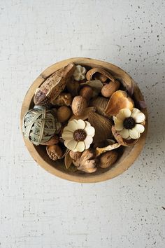 a wooden bowl filled with nuts and flowers