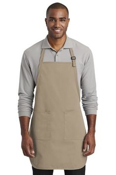 a man wearing an apron and smiling at the camera with his hands in his pockets