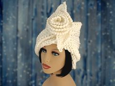 a mannequin head wearing a white crochet hat with a flower on it