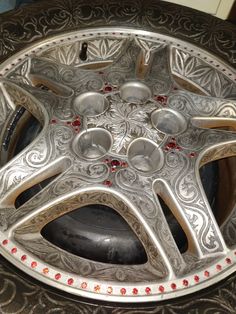 a silver wheel with red and white beads on it