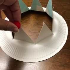 someone is making a paper crown on a table