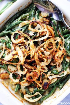 green bean casserole with onion rings in a white dish on a blue tablecloth