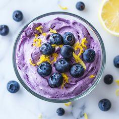 a bowl filled with blueberries and lemons on top of a marble countertop