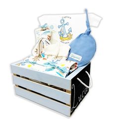 a baby's gift set in a wooden crate with blue and white items on it