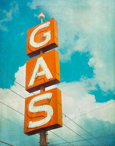 an old neon sign that says gas on the side of a building with power lines in the background