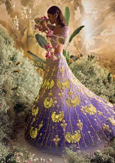 Step into a world of enchantment with our shaded lilac tulle lehenga set - a spellbinding fusion of colors and textures. Watch as custom cut acrylic pieces, gold metal embellishments, and rich fabric appliques come together to create a truly mesmerizing design. Paired with our signature butterfly full-sleeved blouse in lilac silks, and a delicately embroidered tulle dupatta that glistens with metals, pearls, and sequins. Get ready to dazzle and make a statement on your special day! Purple Sets With Sheer Dupatta For Reception, Designer Purple Organza Sharara, Lavender Embroidered Sharara For Wedding, Purple Reception Sets With Sheer Dupatta, Lavender Sharara With Intricate Embroidery For Wedding, Lavender Wedding Set With Sheer Dupatta, Reception Sets With Purple Sheer Dupatta, Lavender Wedding Sharara With Sheer Dupatta, Lavender Sharara With Sheer Dupatta For Wedding