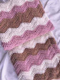 a crocheted blanket laying on top of a bed