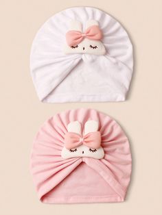 two hats with ears and bows on them, one is white and the other is pink