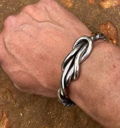 "Custom Viking Knot is all 100% stainless steel! This piece is a Fullheartforge original and is one of the most unique bracelets out there. Also available in a smaller version called the lady viking knot! Custom, hand forged stainless steel bracelet! This material is not made of a high carbon steel that rusts, bends or breaks easily! These bracelets do not leave green or rust marks on the skin and are comfortable to wear continuously. In fact, I have worn mine for 31 years without ever removing Adjustable Twisted Modern Jewelry, Modern Adjustable Twisted Jewelry, Viking Knot, Unique Mens Bracelet, Iron Jewelry, Stainless Bracelet, Bracelet Viking, Viking Designs, Infinity Knot