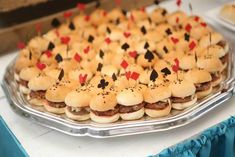 a platter filled with mini hamburgers and playing cards on top of buns