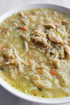 a white bowl filled with chicken and vegetable soup