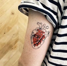 a person with a heart tattoo on their arm