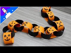 an orange and black paper chain with faces on it