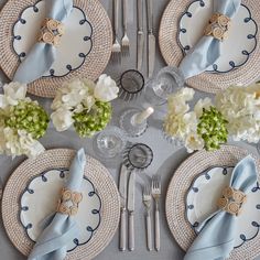 the table is set with blue and white plates, silverware, and napkins