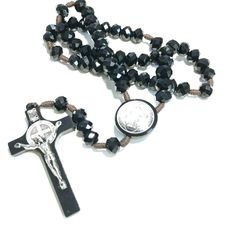 Saint Benedict Rosary blessed by Pope Francis This beautifully made Rosary is hand crafted in Italy. Made of big, black crystal, shiny beads and knotted brown cord. The cross and rosary center are embellished by a sticker which is totally covered by shiny protective enamel. Ideal for a classy person! Look at the big rounded beads. Size is 8 mm. Something out of the ordinary, very elegant. "The intercession of St. Benedict is known to have power and our faith can release this power. The medal is Black Wooden Beads Rosary Spiritual Style, Adjustable Black Rosary With 8mm Beads, Black Wooden Beads Spiritual Rosary, Jesus Passion, Adjustable Rosary With Faceted Round Beads, Black Wooden Beads Rosary, Saint Peter Square, Black Hand-strung Rosary Bracelet With Round Beads, Black Faceted Spiritual Beads