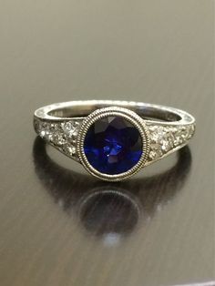 DeKara Designs Collection An Art Deco Platinum Ceylon Blue Sapphire breathtaking ring that must be seen in person to be appreciated.  Metal- 90% Platinum, 10% Iridium.Stones- 1 Round Ceylon Blue Sapphire, 1.83 Carats.  10 Round Diamonds, G color VS1 clarity, 0.36 Carats.  The craftsmanship on this ring is impeccable, and will look extraordinary on a true art lovers finger.  You will wear this ring with great joy, and love.  You will keep glancing at it because it will distract you so much!  Plea Exquisite Diamond-cut Sapphire Ring, Exquisite Diamond Cut Sapphire Ring, Classic Gia Certified Sapphire Ring, Exquisite Gia Certified Round Diamond Ring, Exquisite Sapphire Diamond Ring Gia Certified, Exquisite Gia Certified Sapphire Diamond Ring, Heirloom Sapphire Ring With Accent Stones For Promise, Heirloom Sapphire Promise Ring With Accent Stones, Exquisite Round Cut Sapphire Wedding Ring