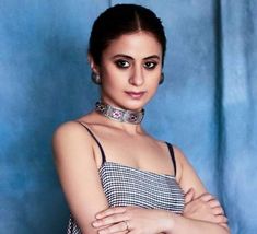 a woman with her arms crossed and wearing a choker around her neck, posing for a photo