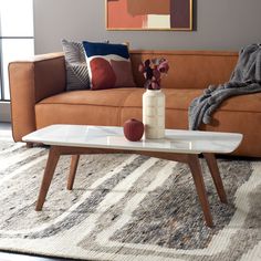 a living room with a couch, coffee table and throw pillows on the rugs