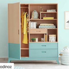 a child's bedroom with blue walls and furniture, including an armoire cabinet