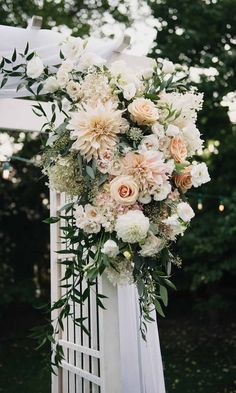 a wedding arch decorated with flowers and greenery