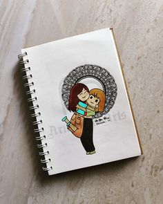 an open notebook with a drawing of a woman holding a baby in her arms on a marble surface