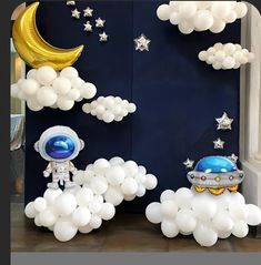 an astronaut balloon decoration with stars and moon in the sky on display at a children's birthday party