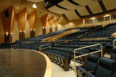 an empty auditorium filled with blue chairs