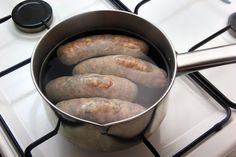 there is a pot full of sausages on the stove