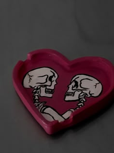 a heart shaped tray with two skeletons in it