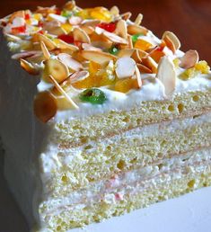 a slice of cake with white frosting and fruit toppings