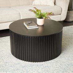 a living room with a white couch and black coffee table on the rug in front of it