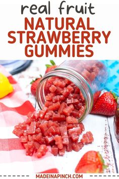 a jar filled with strawberries next to sliced strawberries on top of a table