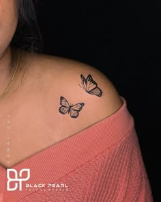 a woman's shoulder with two butterflies on the left side of her arm and an upper half