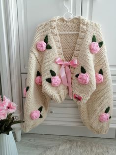 a knitted cardigan with pink roses on it