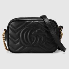 Gucci GG Marmont matelassé mini bag Black with Gold-Tone Trim The mini GG Marmont chain shoulder bag has a softly structured shape and a zip top closure with Double G hardware. The chain shoulder strap has a leather shoulder detail. The camera bag is made in matelassé leather with a chevron design and GG on the back. Black matelassé chevron leather with GG on the back Antique gold-toned hardware Double G Interior open pocket Chain shoulder strap with 23.6" drop Zip top closure Weight: 1.2 lb approximately Mini size: 7"W x 5"H x 2.5"D Made in Italy The model is 5' 10" tall Fits up to: iPhone Pro Max/Plus, Airpods, small wallet, and lipstick WARNING for California residents Microfibre lining with a suede-like finish MATERIALS AND CARE Gucci products are made with carefully selected materials Gg Marmont Matelassé Mini Bag, Gg Marmont Mini Bag, Gucci Gg Marmont Matelasse, Gg Marmont Mini, Gucci Mini, Gucci Gifts, Making Stuff, Paris Mode, Mini Cross