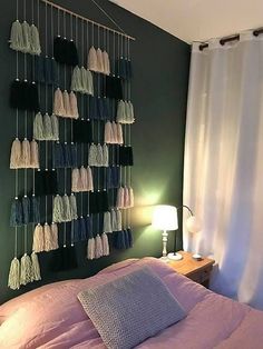 a room with a bed, lamp and wall hangings on the wall above it