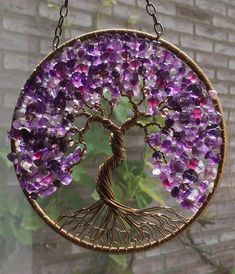 a purple tree hanging from a chain on a brick wall