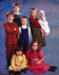 a group of young children posing for a photo in front of a blue background,