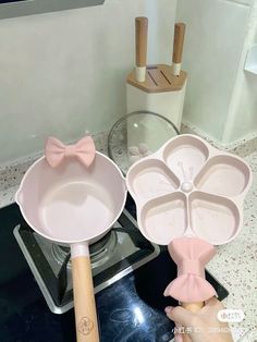 two pans with bow ties on them sitting on top of a stove next to a baking utensil