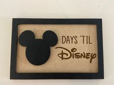 a mickey mouse shadow frame with the words days'til disney on it in brown and black