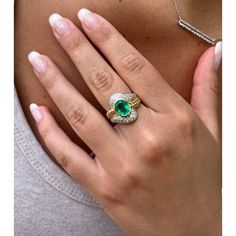 Natural emerald and diamond ring, featuring a magnificent 2.80-carat oval cut emerald, accompanied by 0.38 CTTW round cut diamond side stones, all beautifully set in a wavy textured 18K yellow gold motif. Set with an open back that allows for the emeralds natural color to be on full display.   The wavy textured yellow gold adds a touch of uniqueness to this vintage piece, making it a symbol of elegance and sophistication. A ring with a moderate elevation off the finger that sits beautifully on t Oval Emerald Rings With Pave Setting, Oval Emerald Ring With Pave Setting For Anniversary, Oval Emerald Ring With Pave Setting, Oval Emerald Ring With Pave Diamond Setting, Oval Emerald Ring With Diamond Pave Setting, Oval Cubic Zirconia Emerald Ring In Fine Jewelry Style, Oval Emerald Ring With Diamond Accents For May Birthstone, Gia Certified Oval Emerald And Diamond Ring, Oval Diamond Ring For May Birthstone