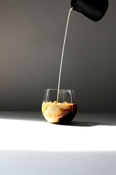 a glass filled with liquid sitting on top of a table