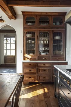 an old fashioned kitchen with wood floors and cabinets in the center, along with a wooden dining room table