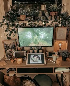 a computer desk with plants and pictures on it