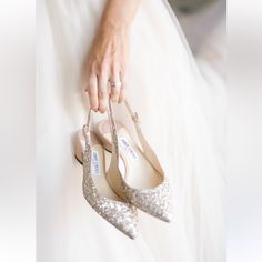 a bride's wedding shoes and ring on her finger