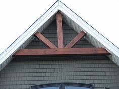 the top of a house with a clock on it's face and an open window