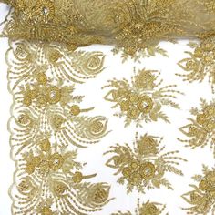 gold and white embroidered fabric with flowers on it